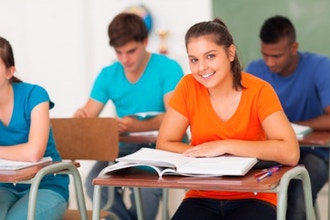 smiling student sitting at desk in classroom