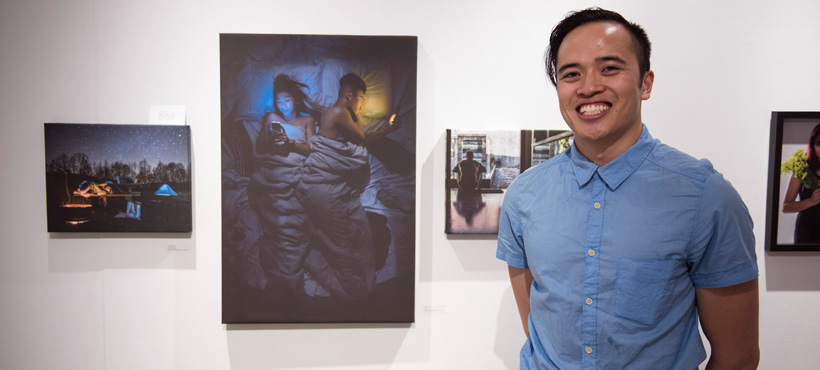 Mohawk student standing in front of artwork on wall