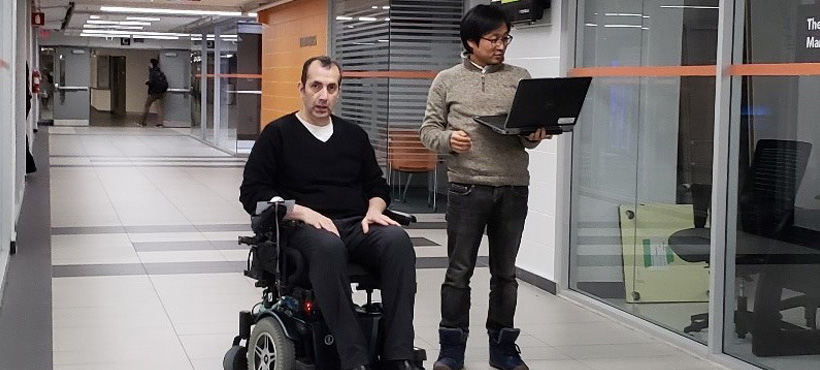 Mohawk student with a gentleman in the smart wheelchair