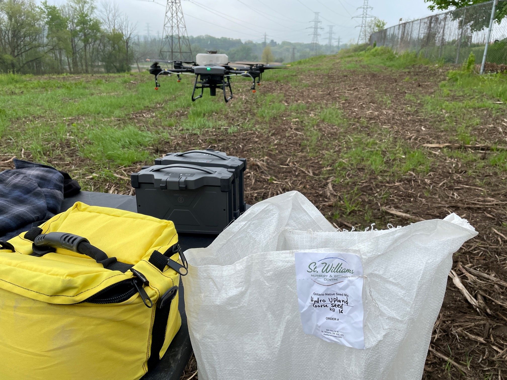 Picture a drone flying over a field, and a bag of seeds.