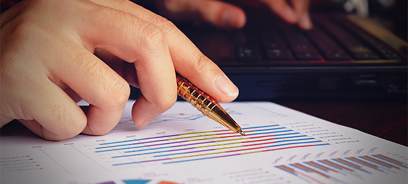 A hand with a pen, reviewing a report