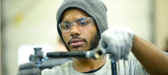 skilled trade student painting a car