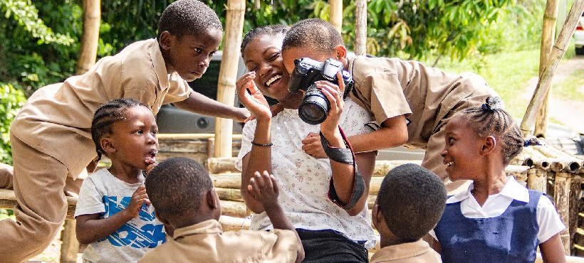 Mohawk student laughing with children