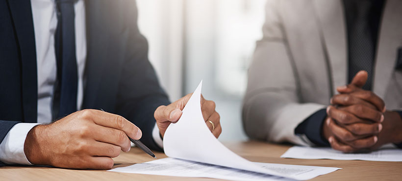 Two people at a meeting reviewing paperwork