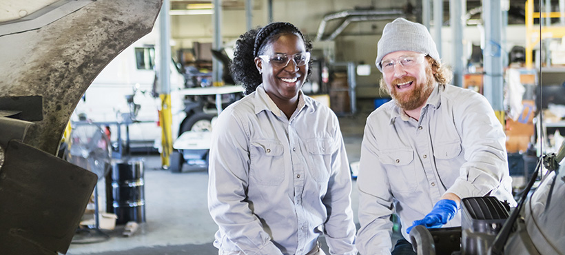 Female and male mechanics having fun at work