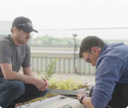 Two people working on a solar panel outside