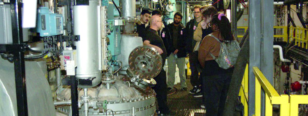 Students on a catwalk in a chemical plant.