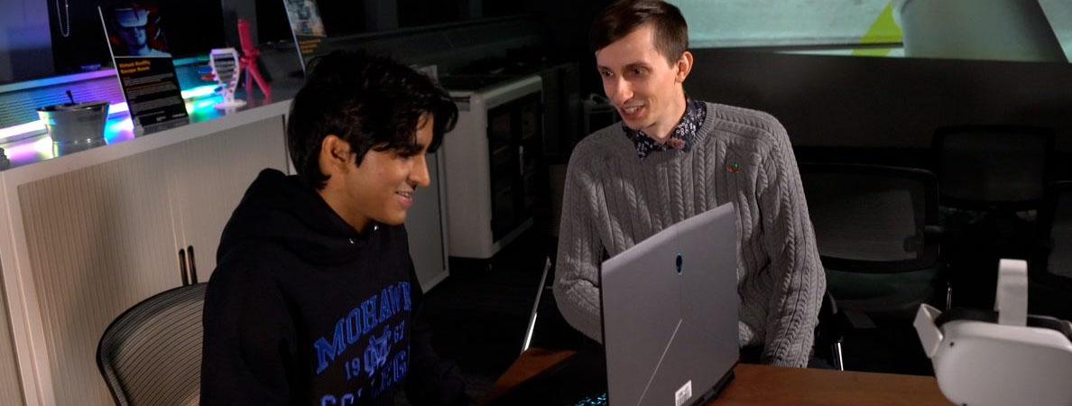 Faculty and student working on a laptop