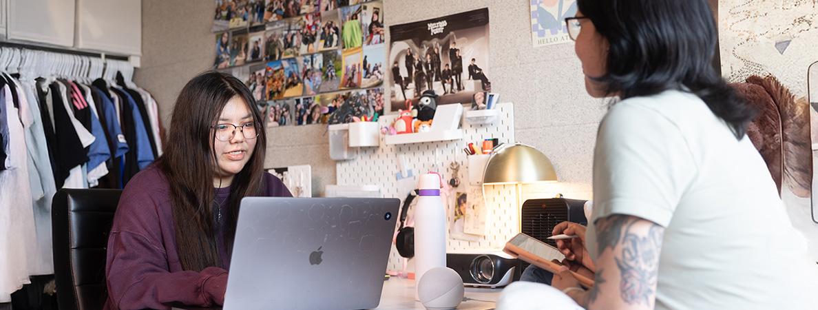 Two students talking in their residence room.