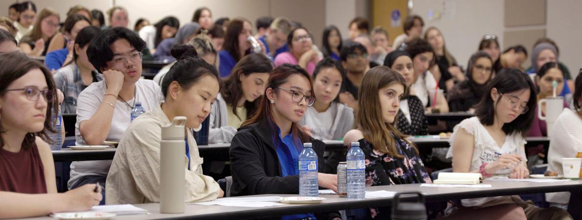 Students listening attentively in a lecture hall.