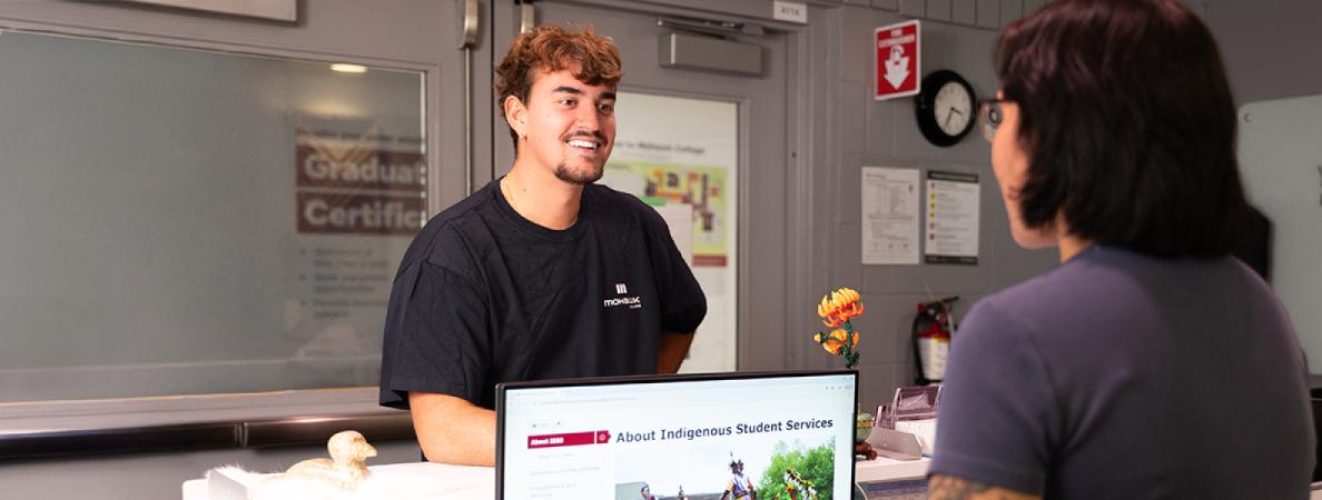 Student talking to a secretary.