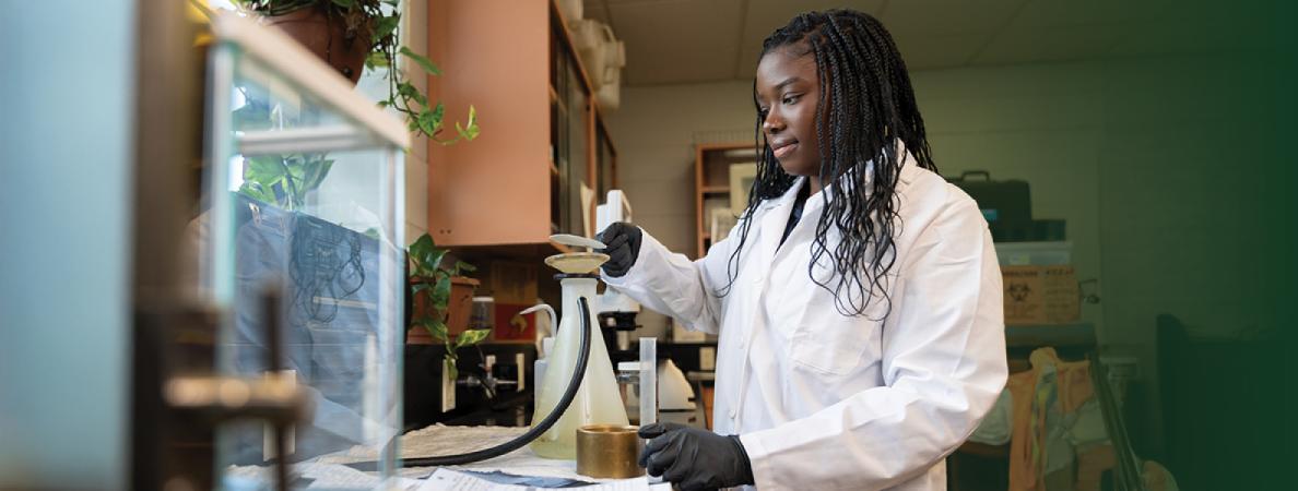 Tamiah in a lab coat with a beaker in a laboratory.