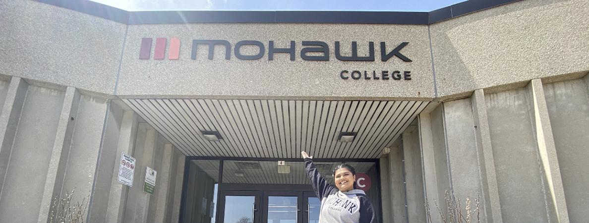 Mohawk College is in the background of a photograph of a student