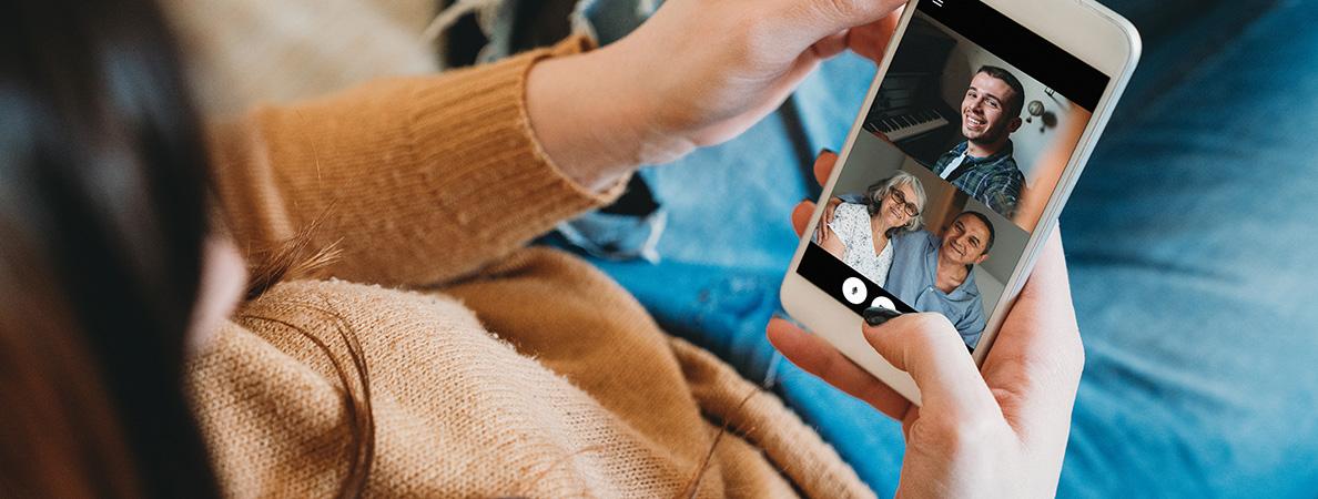 woman holding cellphone video chatting with 3 people