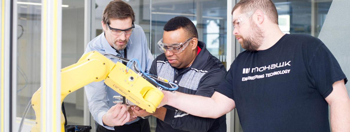 Prior to 2019 photo of faculty and students in the FANUC Robotics Lab
