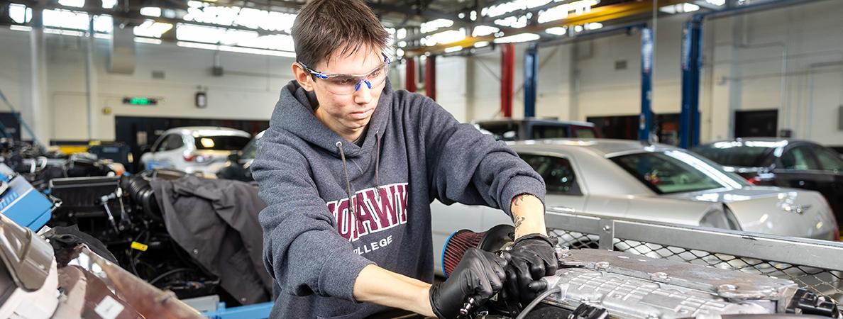 Keywayden working on a car engine in a Mohawk College automotive lab.