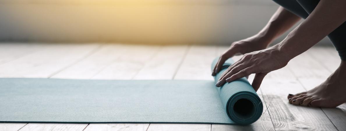 close-up of woman unfolds yoga mat with hands