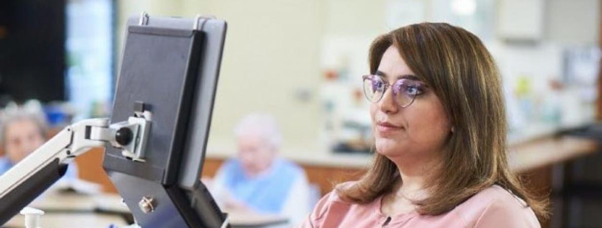 woman in pink scrubs looking at computer