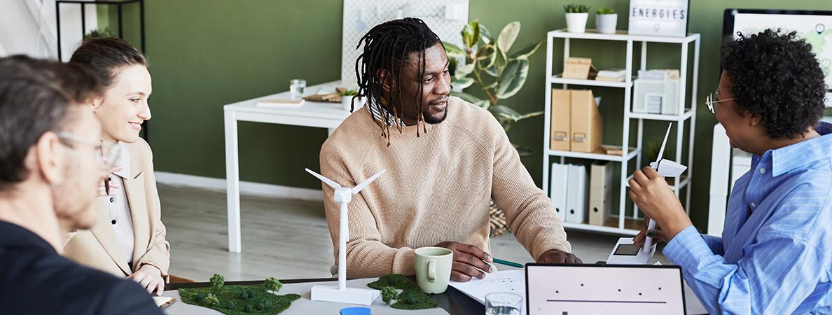 A group of people around a table discussing sustainability management initiatives.