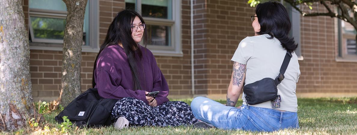 Brooke sitting on grass with a friend