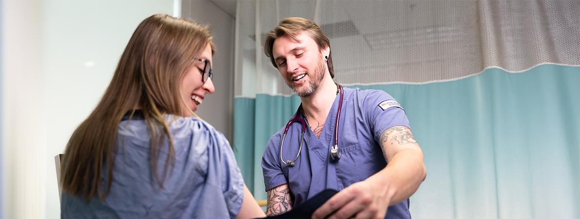 Two medical students demonstrating a pressure cuff.