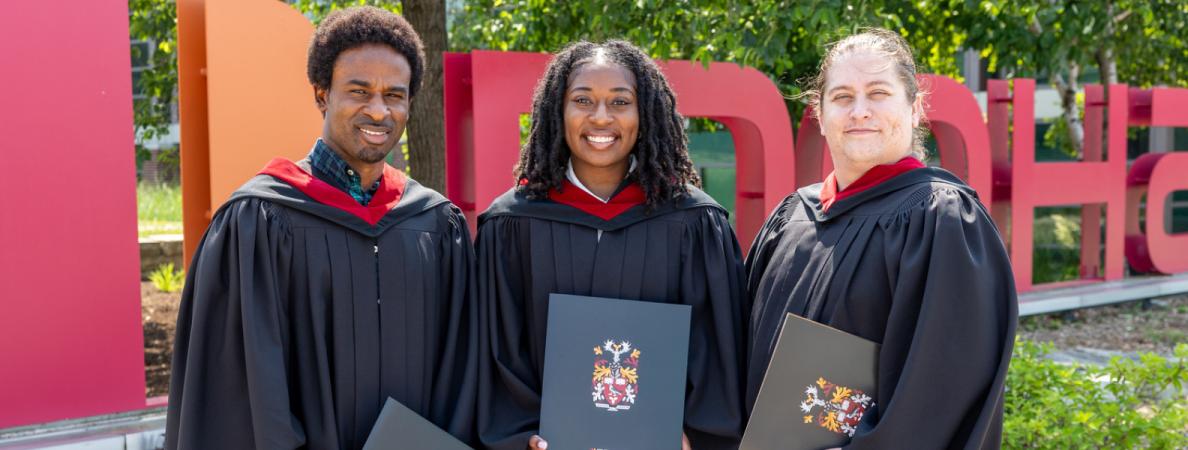 Grad students in front of Mohawk sign.