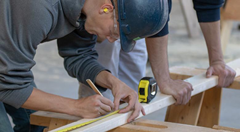 student measuring wood