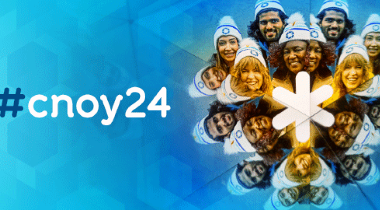 People smiling and gathered around each other wearing toques