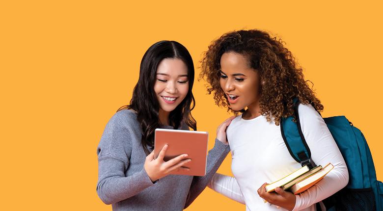 two individuals smiling while looking at a tablet