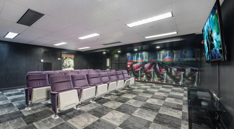 Movie lounge with 30 authentic theatre seats, a movie mural along the wall. 