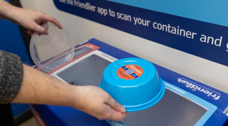 A picture of staff throwing out Friendlier container into a Friendlier return bin at Fennell campus.