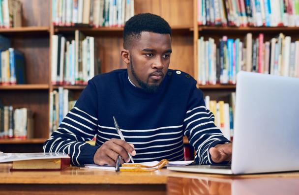 Person studying on a laptop in a library space