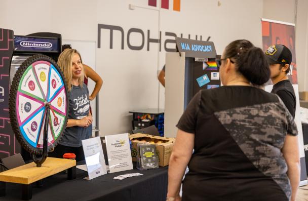 staff person talking to student across table and spin wheel is visible