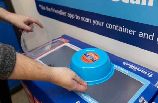 A picture of staff throwing out Friendlier container into a Friendlier return bin at Fennell campus.