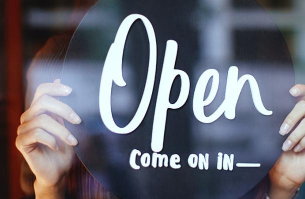 Person holding an "Open sign"