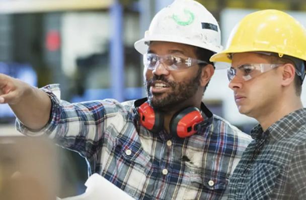 Photo of two trades managers talking