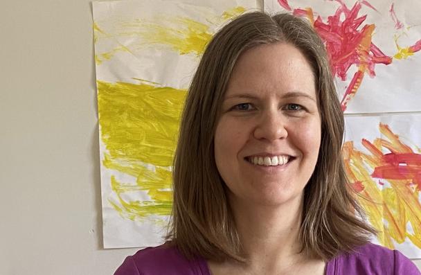 woman standing in front of children's painting