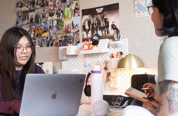 Two students talking in their residence room.