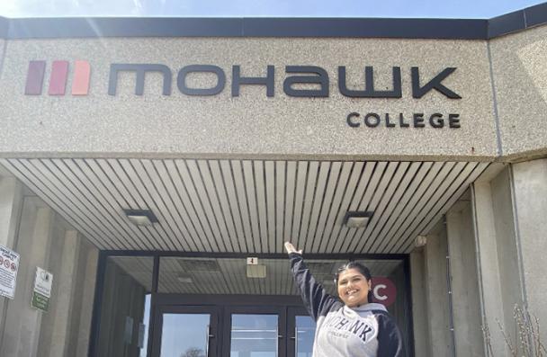 Mohawk College is in the background of a photograph of a student