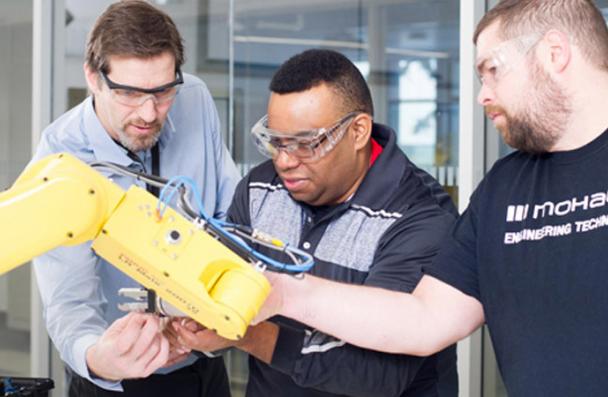 Prior to 2019 photo of faculty and students in the FANUC Robotics Lab
