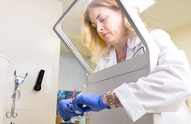 A student in a lab coat in a laboratory.