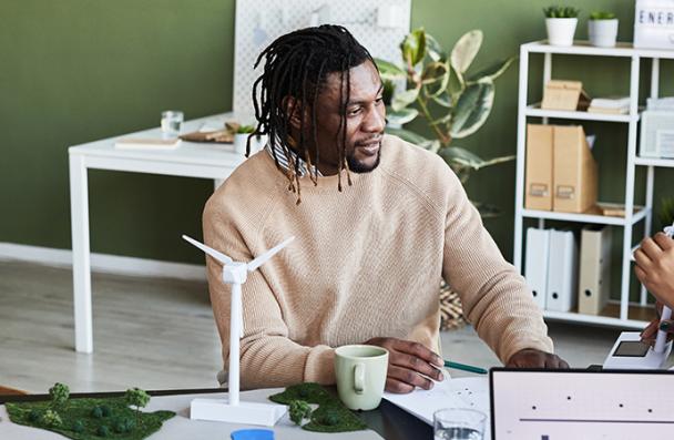 A group of people around a table discussing sustainability management initiatives.