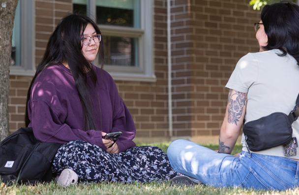 Brooke sitting on grass with a friend