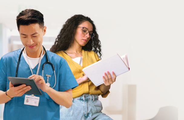 Two students reading charts and tablets.