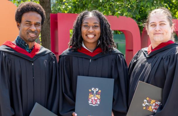 Grad students in front of Mohawk sign.