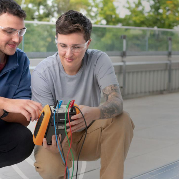 A student working on solar panel with an instructor.