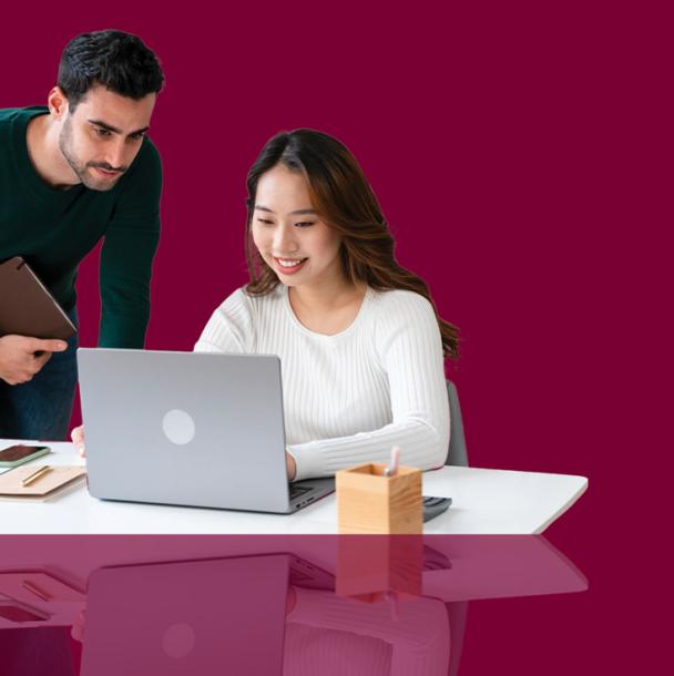 A student success advisor helping student on their computer