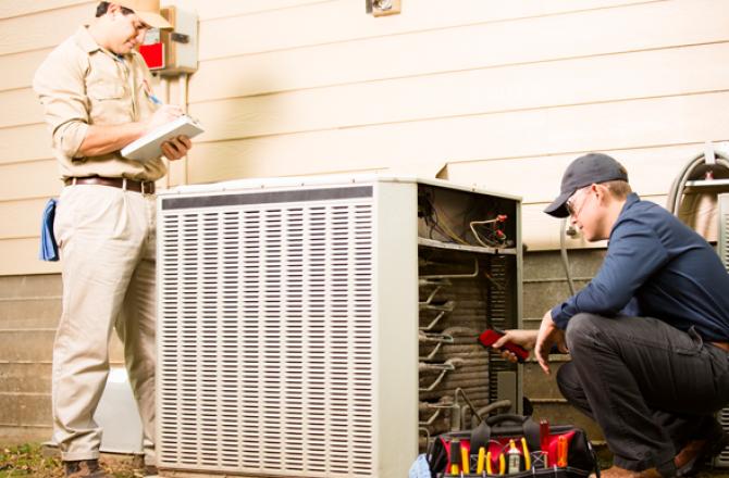 Mechanics analyzing a large air conditioning unit.