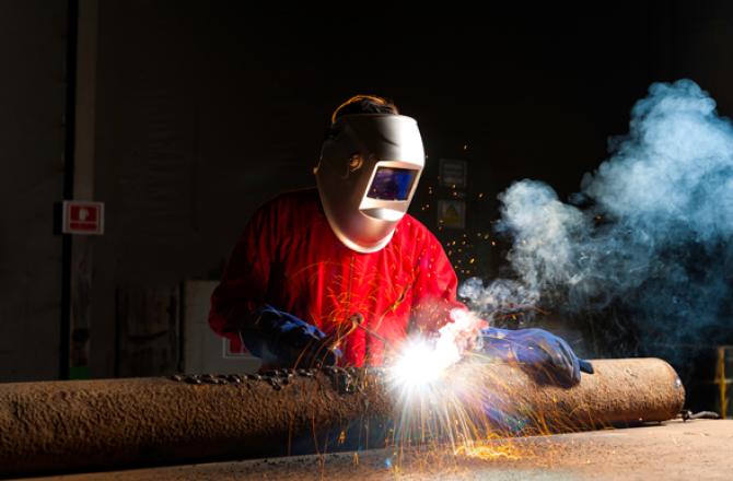 Welder fastening components together using tack welding.
