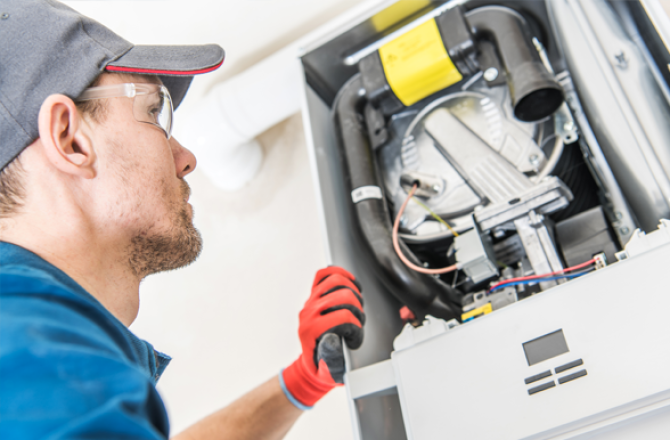 Gas and oil burner technician examining equipment.